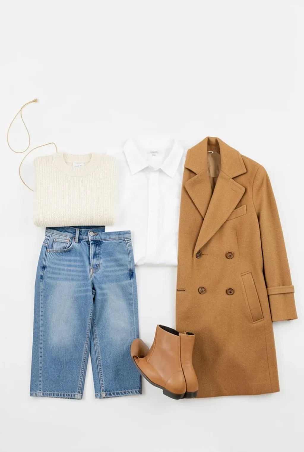 An overhead flatlay of a neutral capsule wardrobe with sweater, jeans, coat and boots