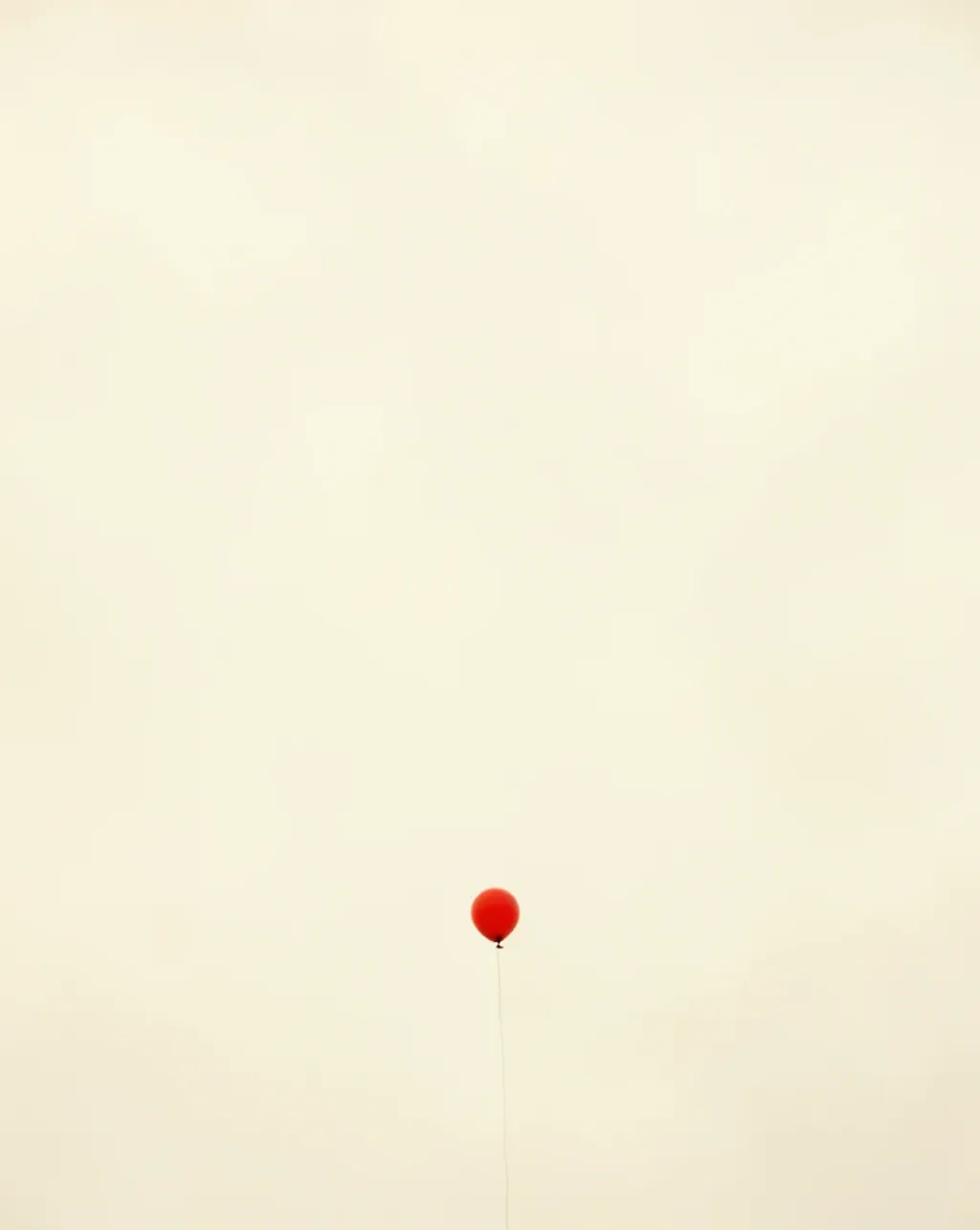 One small red balloon floating in a vast pale sky, minimalist Midjourney v7 render